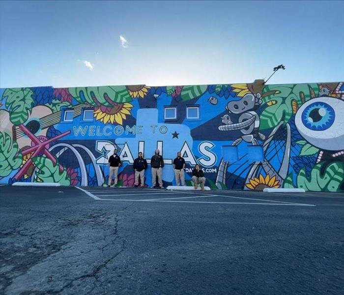 SERVPRO technicians posing in front of Dallas, Texas graffiti mural